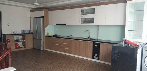 Tủ bếp nhựa Picomat cánh phủ Acrylic nâu vân gỗ kết hợp trắng vách kính trắng